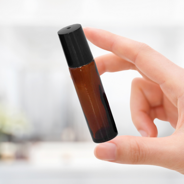 Hand holding a 10ml aromatherapy roll on bottle for relative size