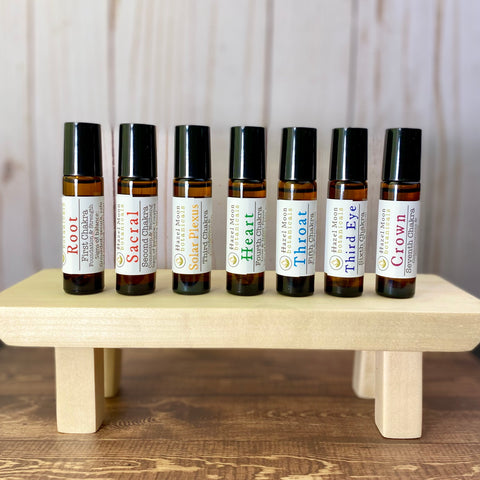 7 Chakras 10ml Aromatherapy Roll On Bottles left to right: Root, Sacral, Solar Plexus, Heart, Throat, Third Eye, Crown. 10ml Amber Glass Roll On bottles with Black lids.